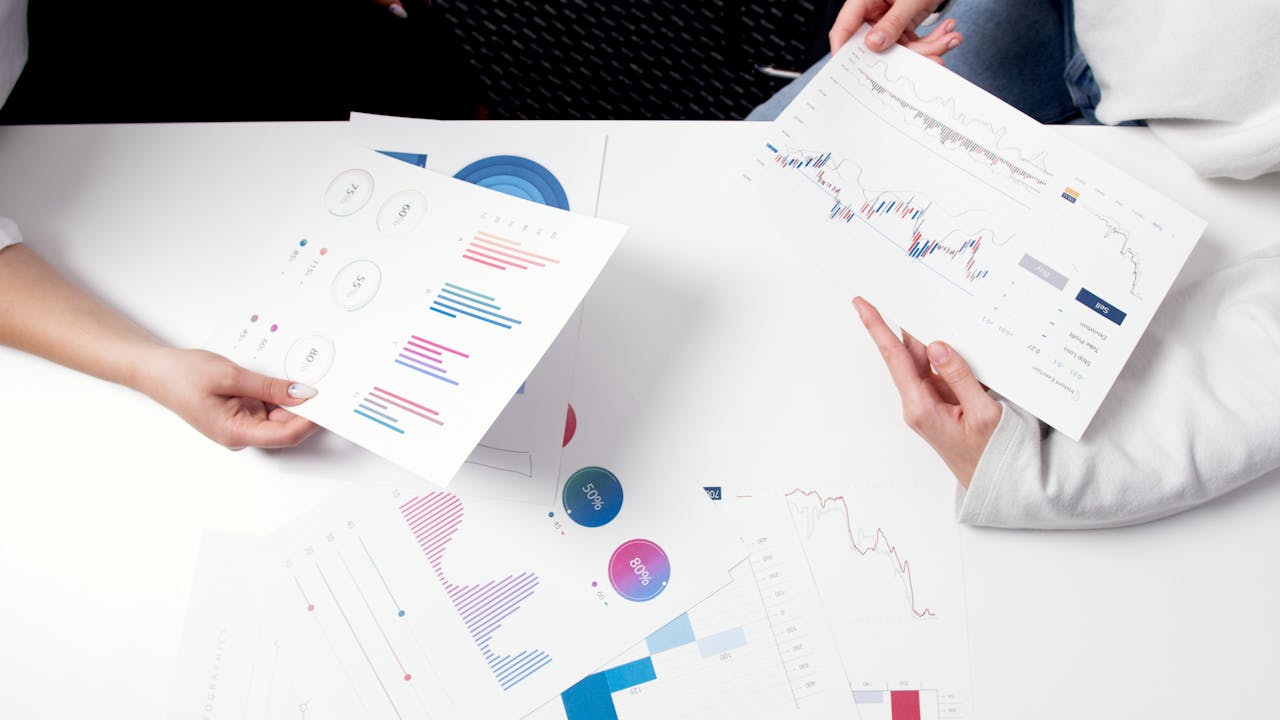 Hands holding business charts and graphs during a meeting, showcasing financial analysis and investment strategy.